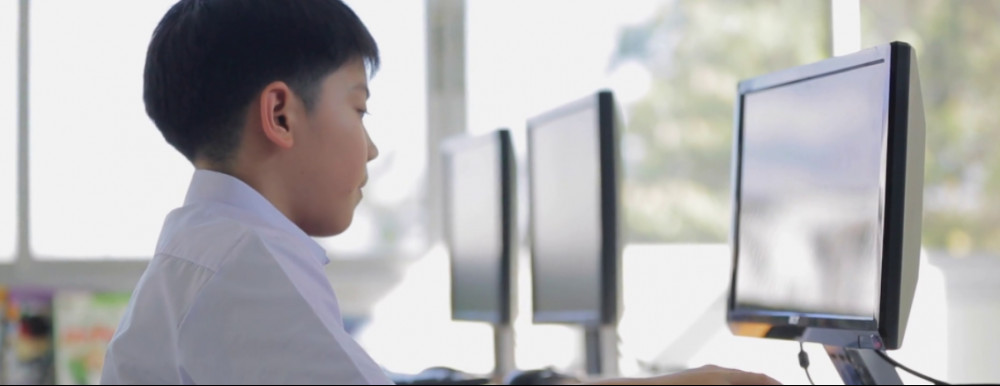 Asian child in front of computer